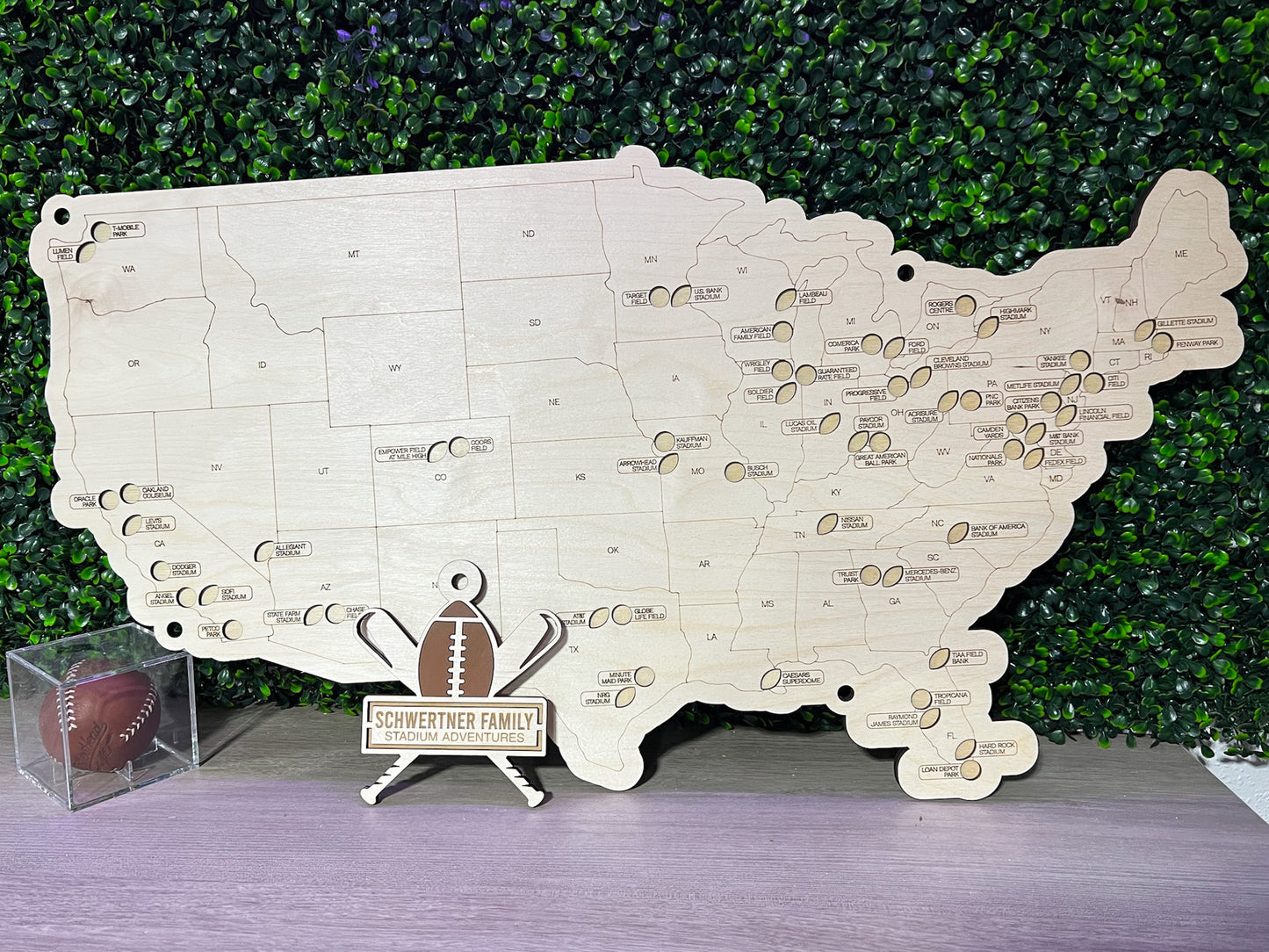 football and baseball themed travel map on wood, with greenery background