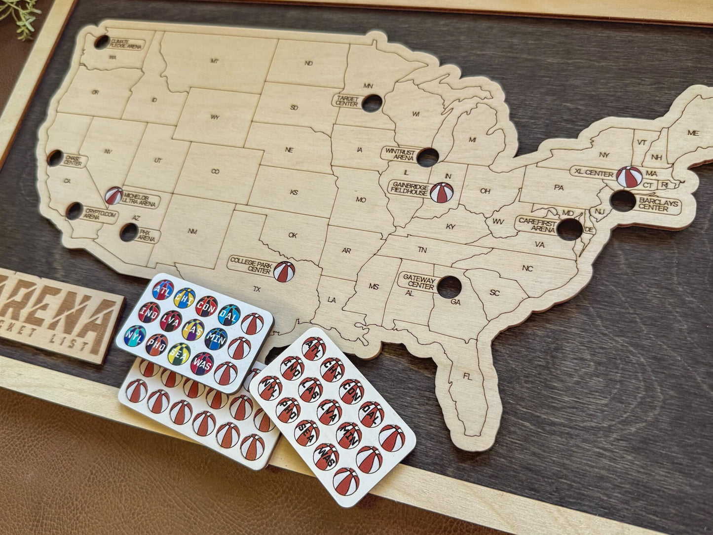 Wooden map of the United States with corresponding stickers on a dark surface