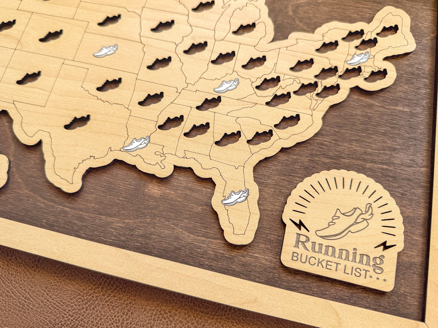 Wooden travel map on dark wood surface and shoe sticker tokens with "Running Bucket List" in the corner