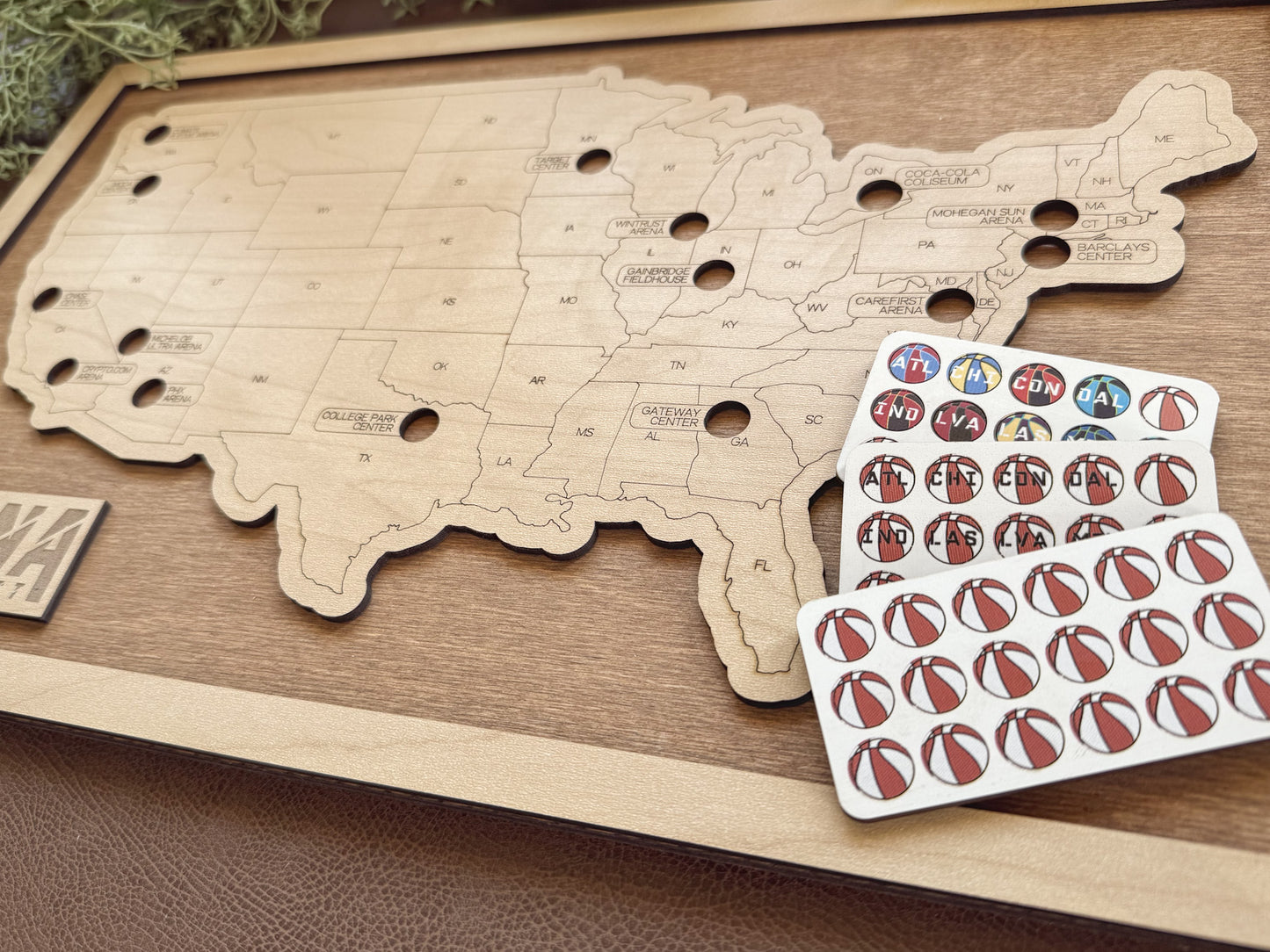 Wooden map of the United States with a set of wooden pins on a wooden surface