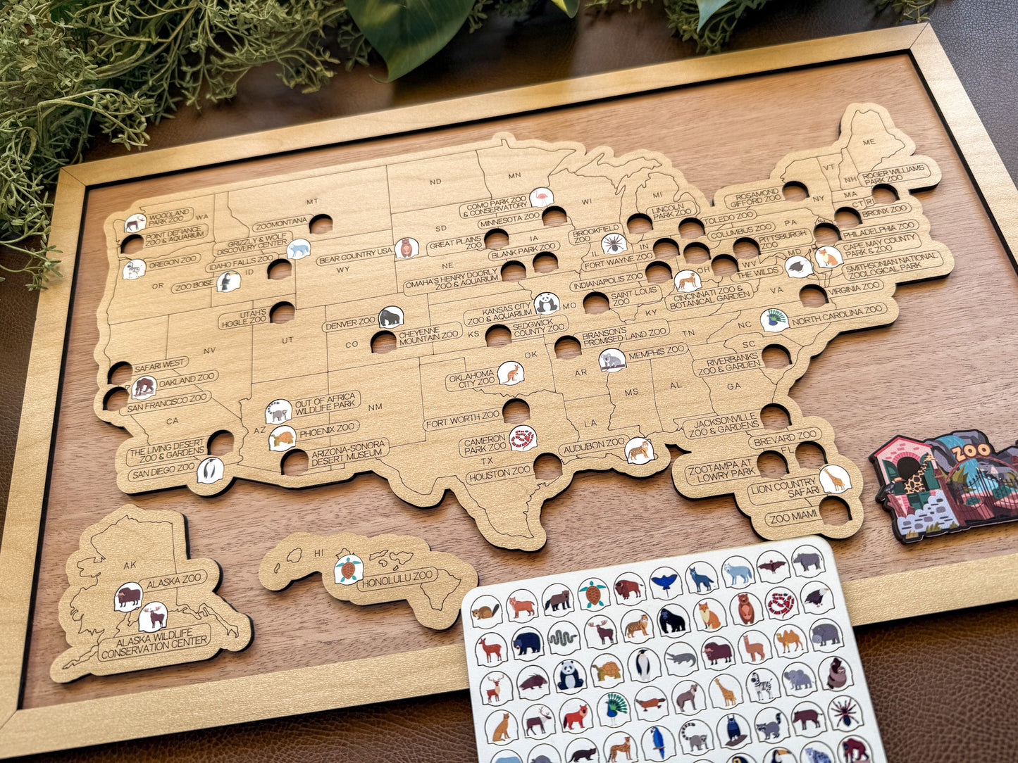 Wooden map of the United States with cut-out states and animal stickers on a wooden surface.
