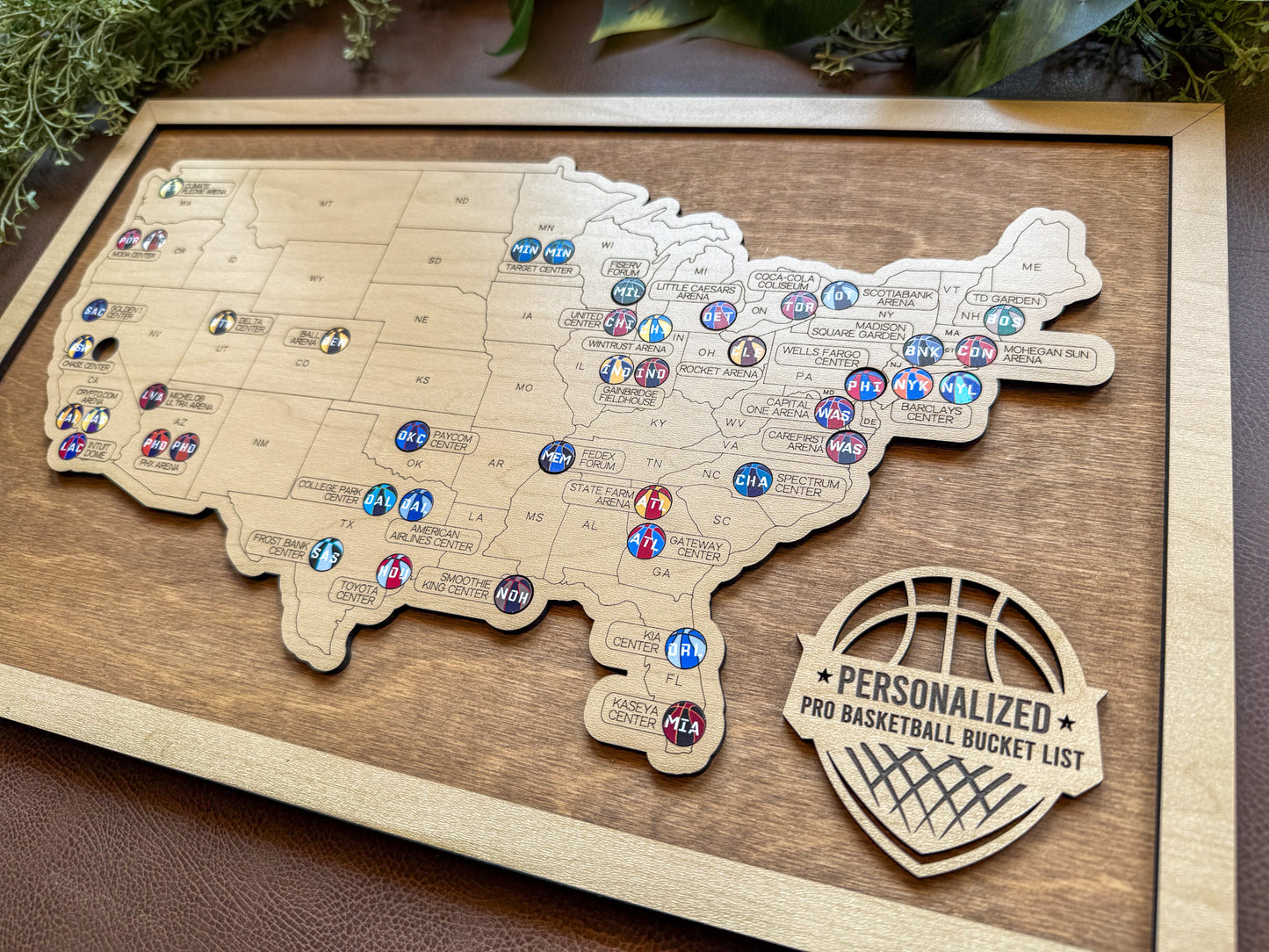 Wooden map of the United States with basketball-themed pins on a wooden board.