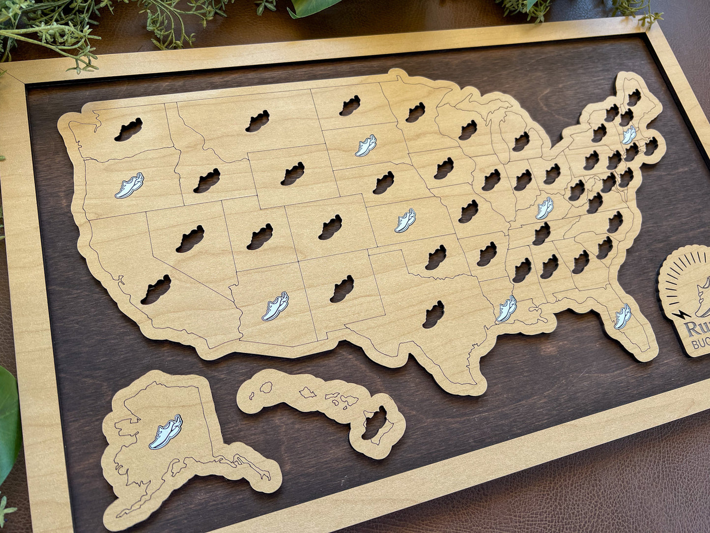 Wooden map of the United States with cut-out shoe holes on a wooden board.