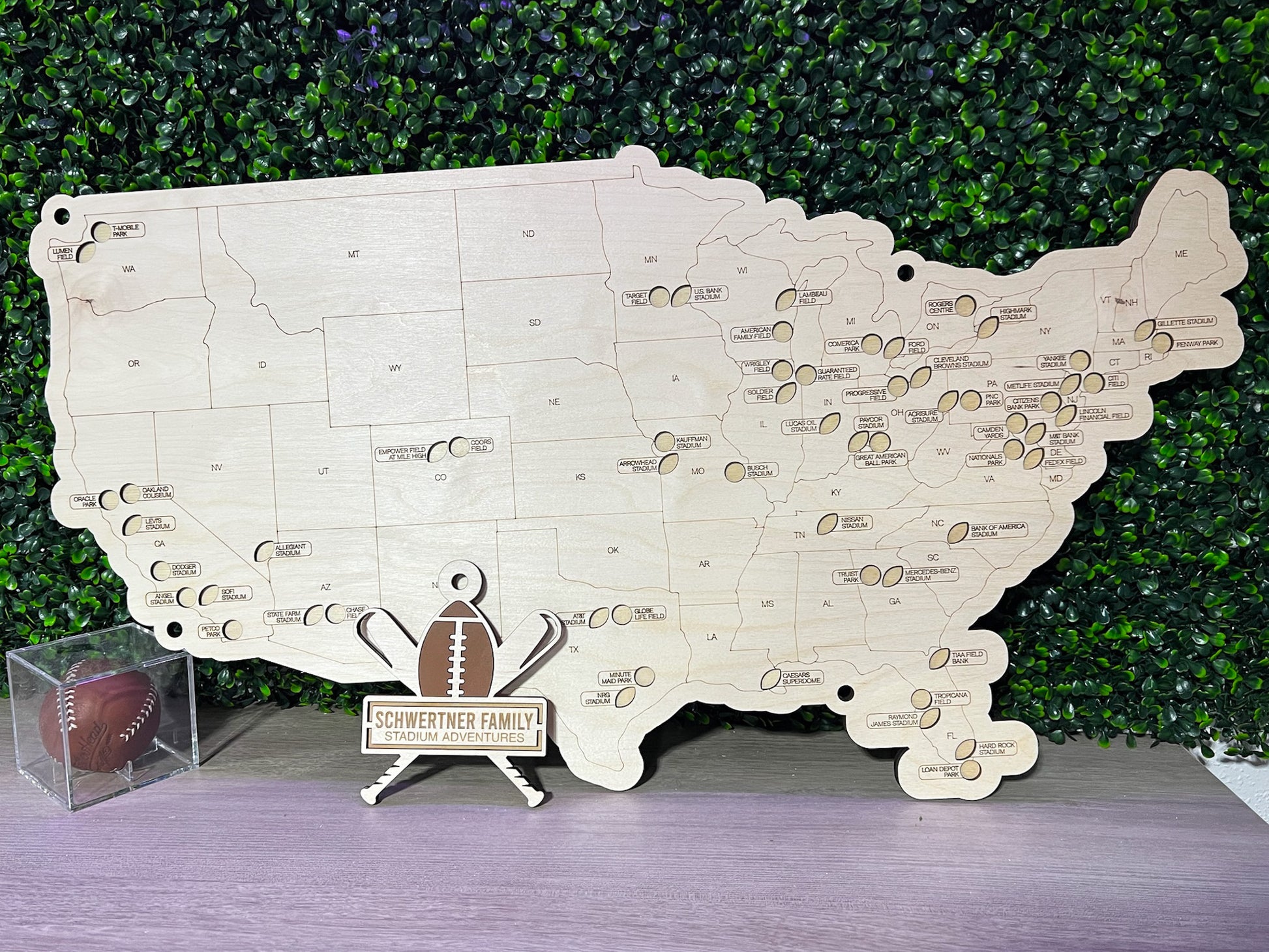 football and baseball themed travel map on wood, with greenery background