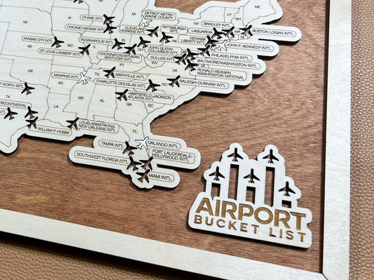 A map showcasing airport locations with plane tokens, labeled 'Airport Bucket List', positioned on a wooden surface with a natural brown border.