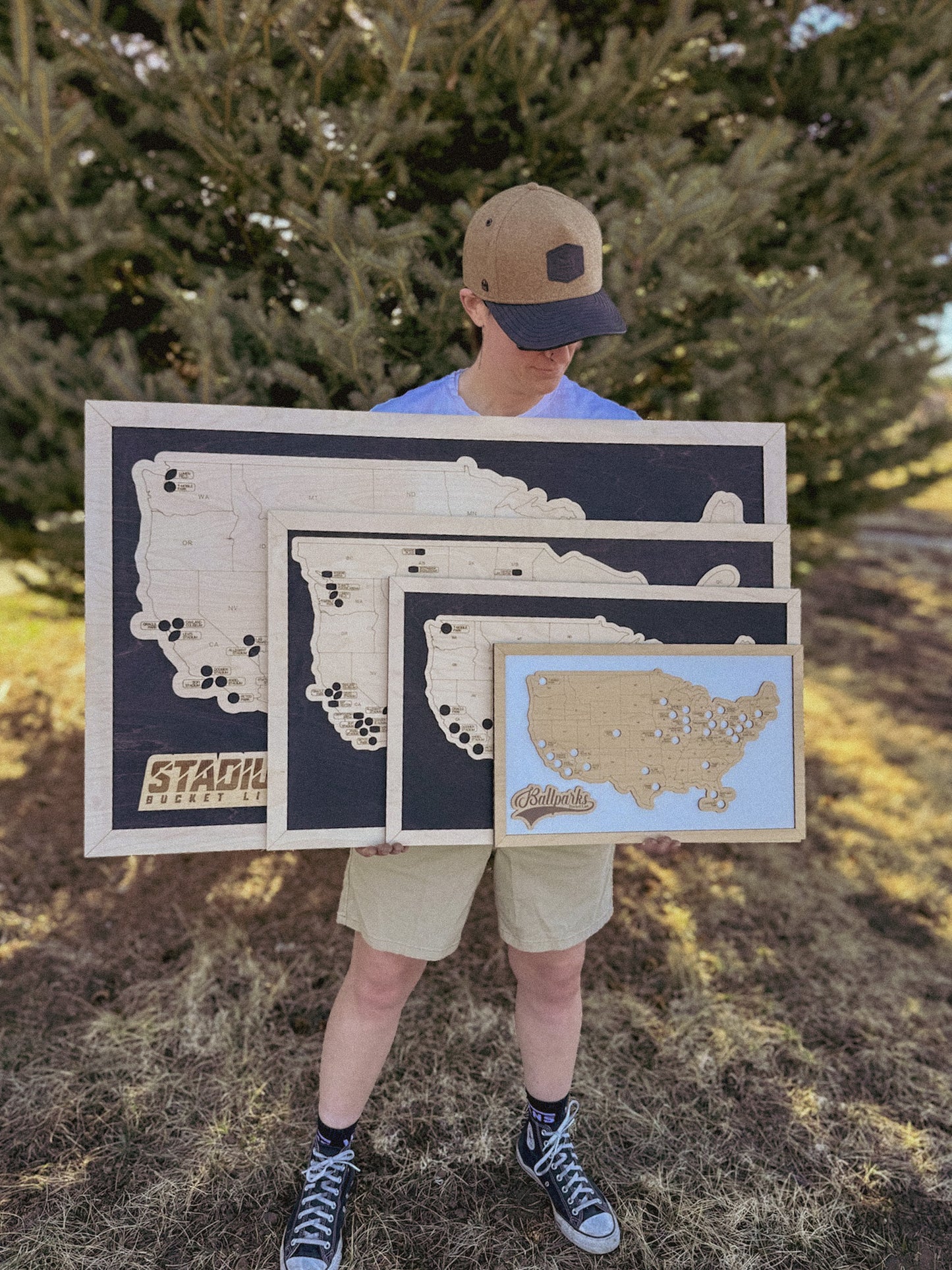 Person holding a wooden map of the United States outdoors
