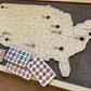 Wooden map of the United States with corresponding stickers on a dark surface