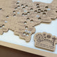 Wooden map of the United States with cutouts and 'Amusement Park Bucket List' plaque.