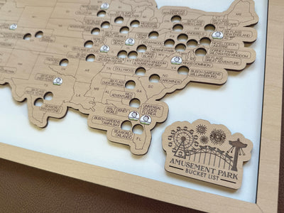 Wooden map of the United States with cutouts and 'Amusement Park Bucket List' plaque.