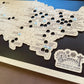 Map of amusement parks with pins and a logo on a wooden board