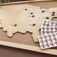 Wooden map of the United States with a set of wooden pins on a wooden surface