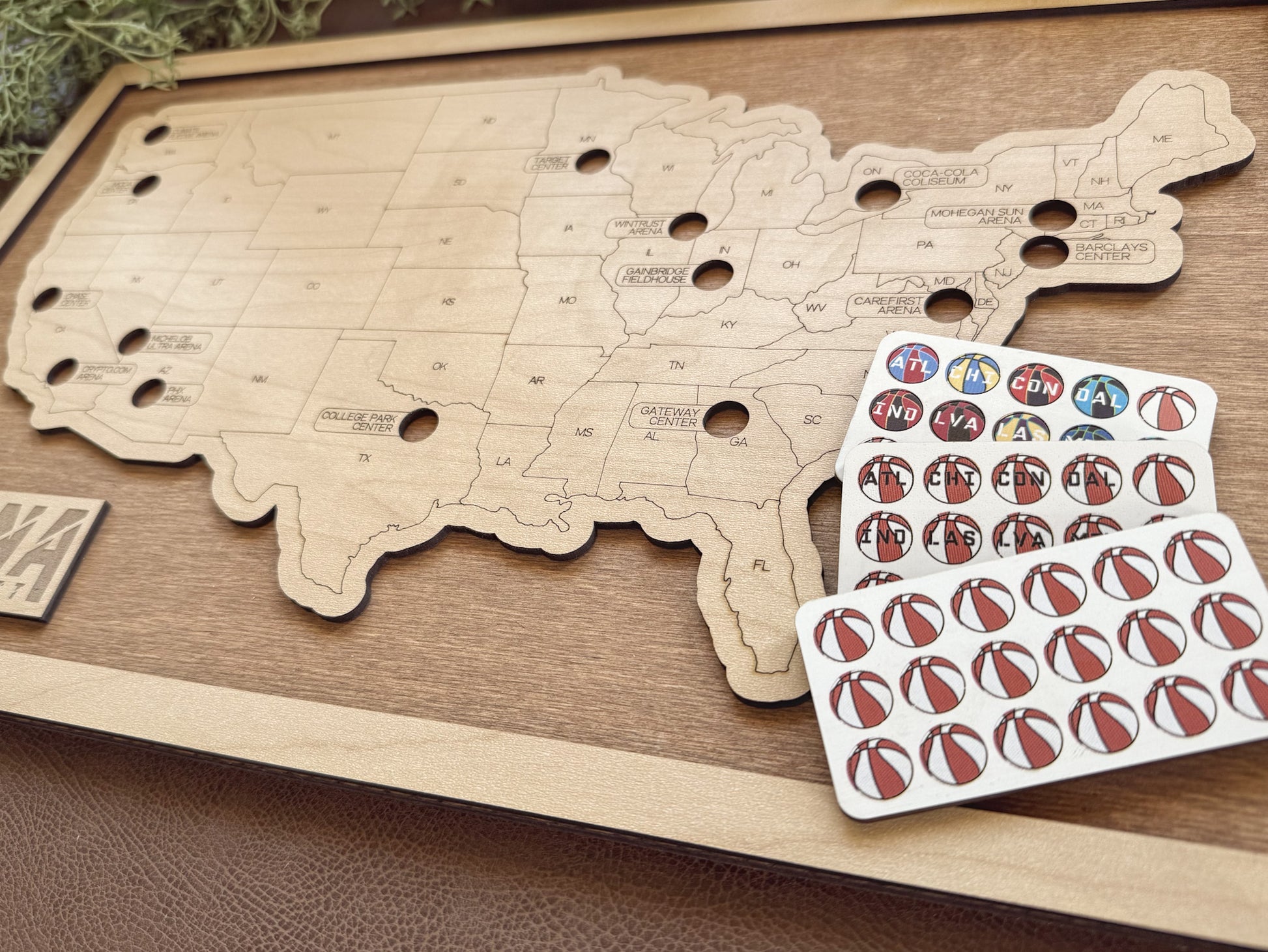 Wooden map of the United States with a set of wooden pins on a wooden surface