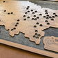 Wooden map with cut-out shapes and text on a wooden board