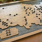 Dark wood map of the United States with cut-out states on a wooden surface