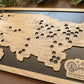 Wooden map of the United States with cut-out states on a dark surface