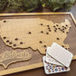 Wooden map of the United States with cut-out states, 'Ballparks Bucket List' branding, and a stack of cards on a wooden surface.