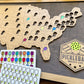 Wooden map of the United States with pickleball-related items on a wooden surface. close up