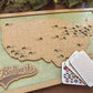 Wooden map of the United States with cut-out states, 'Ballparks Bucket List' branding, and cards on a wooden surface.