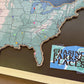 Map of the United States with pins and a card titled 'Chasing Parks & Places' on a dark surface.