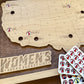 Wooden map of the United States with 'Women's Arena Bucket List' sign and sticker token sheets.