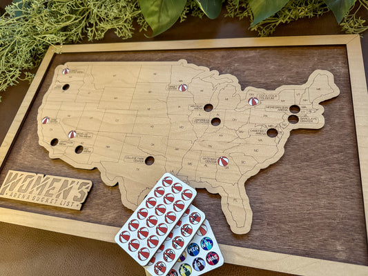 Wooden map of the United States with pins and a plank of sticker tokens on a wooden surface.