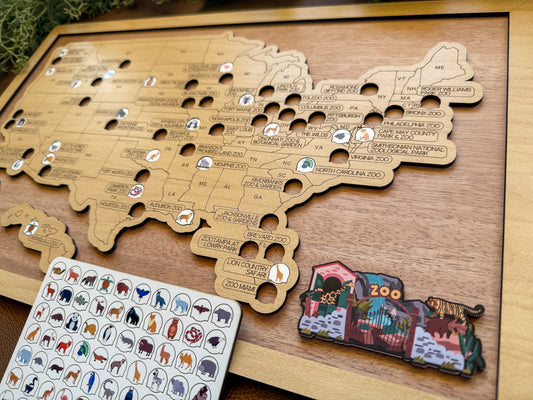 Wooden map of the United States with animal sticker tokens and zoo bucket list sign on a wooden surface.
