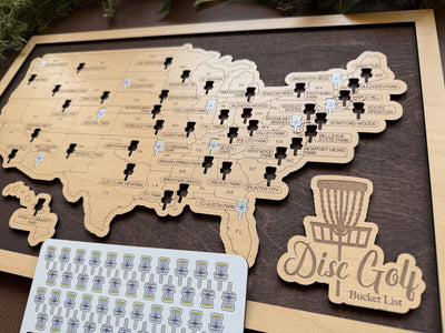 Wooden map of the United States with disc golf course markers on a wooden board.