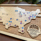 Wooden map of the United States with basketball-themed pins on a wooden board.