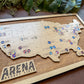 Wooden map of the United States with pins labeled 'Arena Bucket List' on a wooden board.