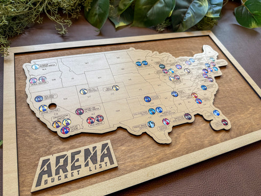 Wooden map of the United States with pins labeled 'Arena Bucket List' on a wooden board.