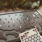 Map of the United States with ghost symbols and a card with more ghost symbols on a wooden surface.