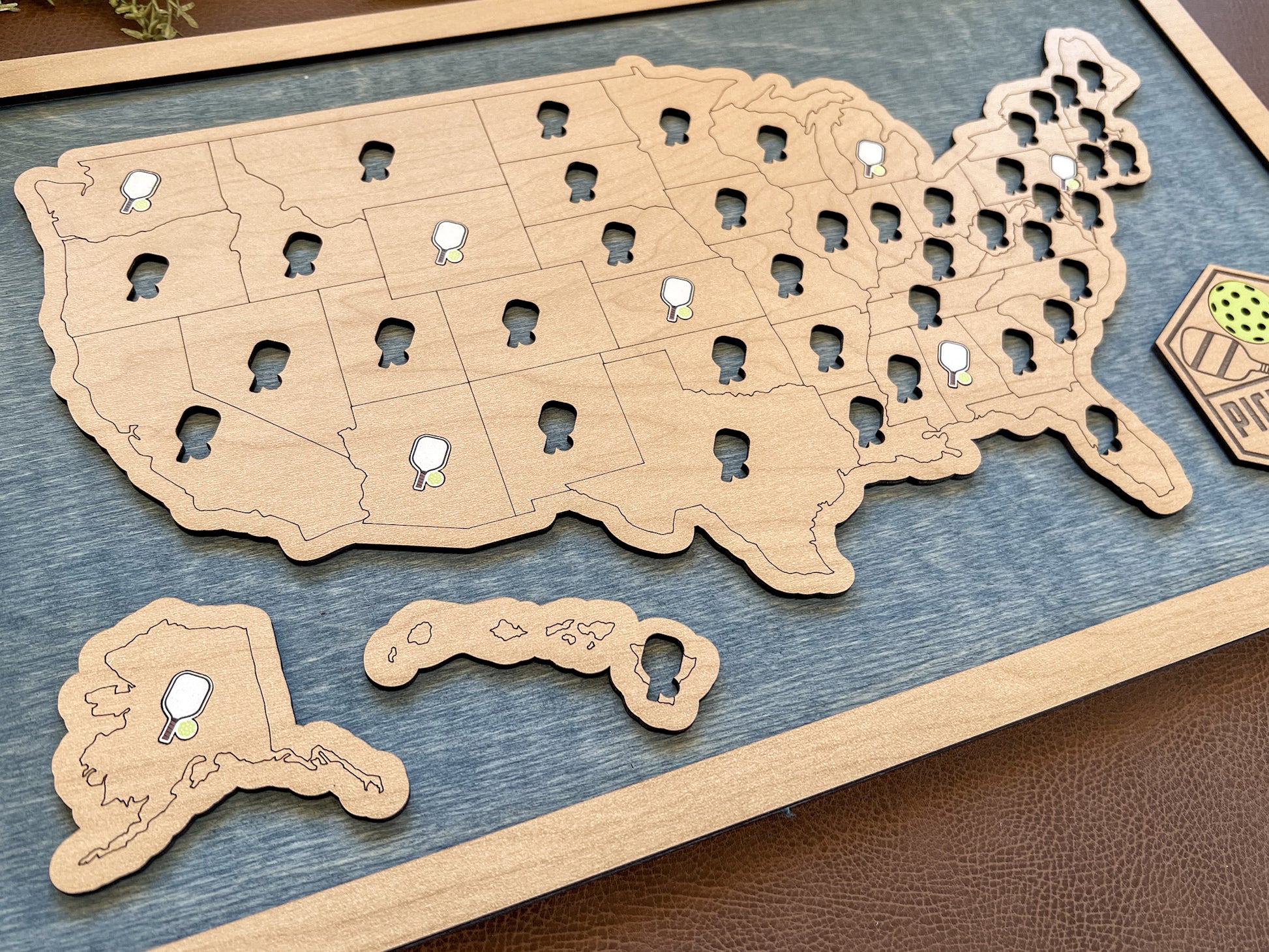Wooden map of the United States with cut-out states on a blue background