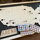 Wooden map of the United States with Arena Bucket List stickers on a dark surface
