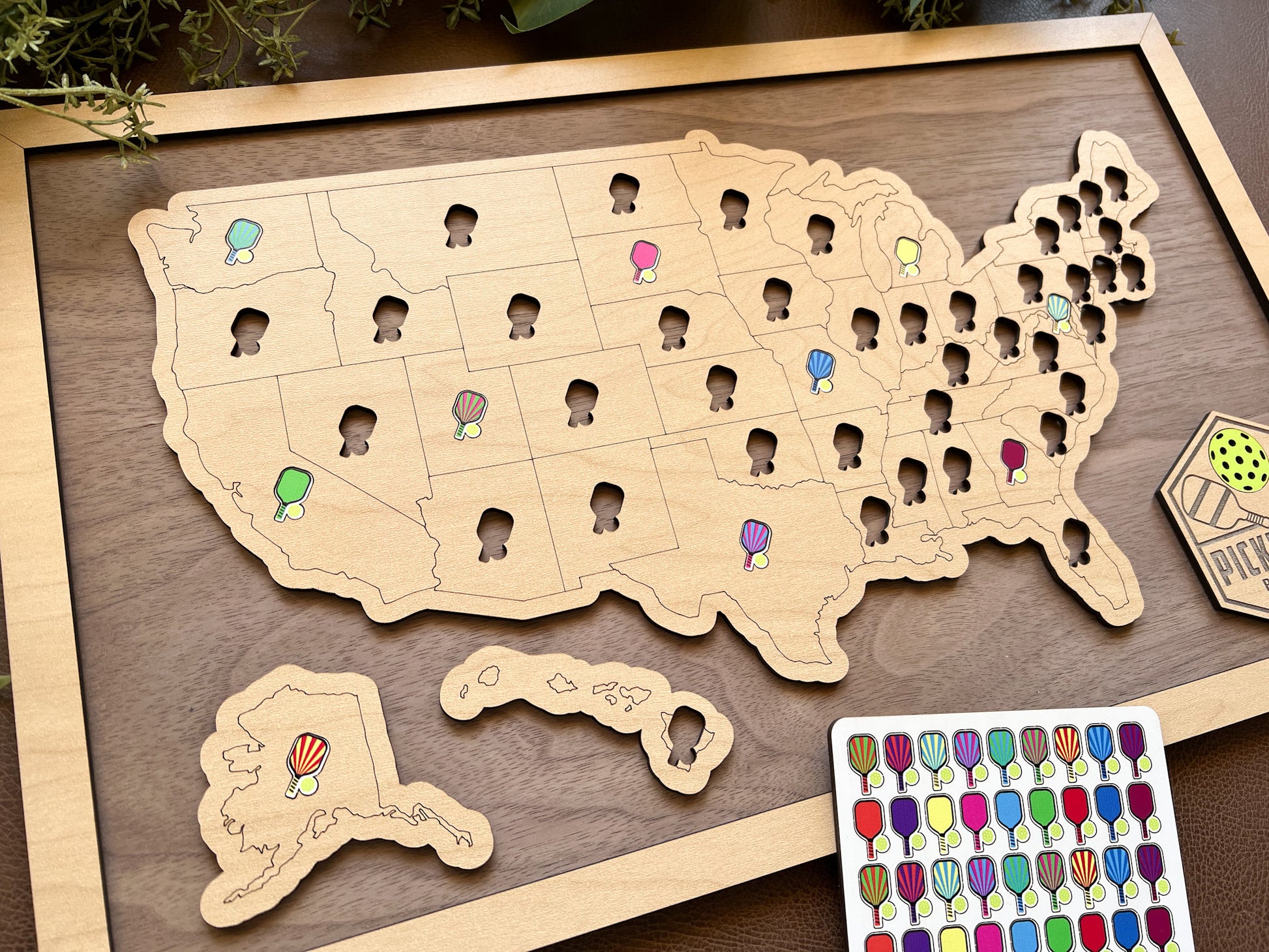 Wooden map of the United States with pins and a color swatch on a wooden board.