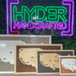 A collection of sport-themed tracking maps with pins, displayed in front of a neon sign that reads 'Hyder Handcrafted'.